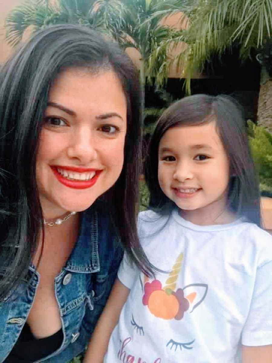 Woman wearing bright red lipstick takes a selfie of her and her 10-year-old daughter