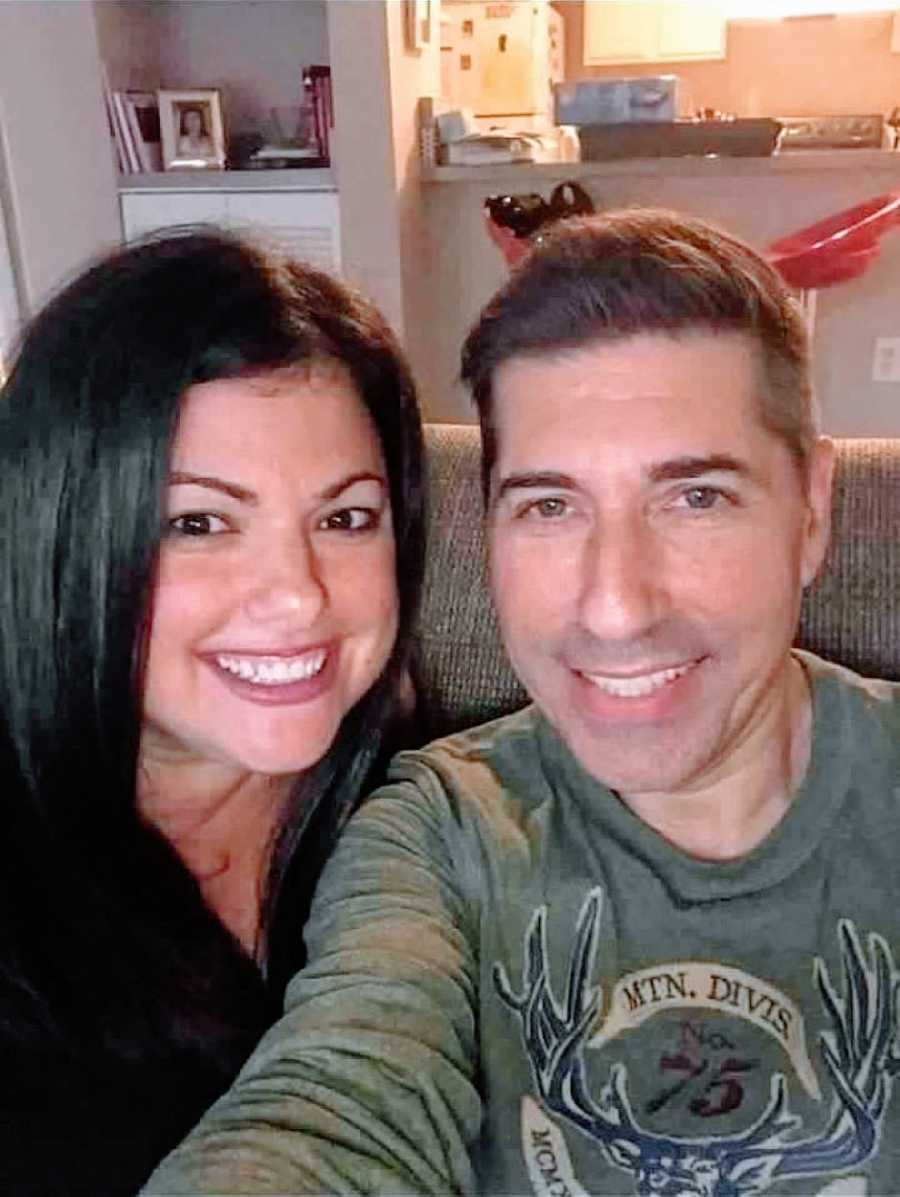 Couple take selfie while snuggling up at home on the couch