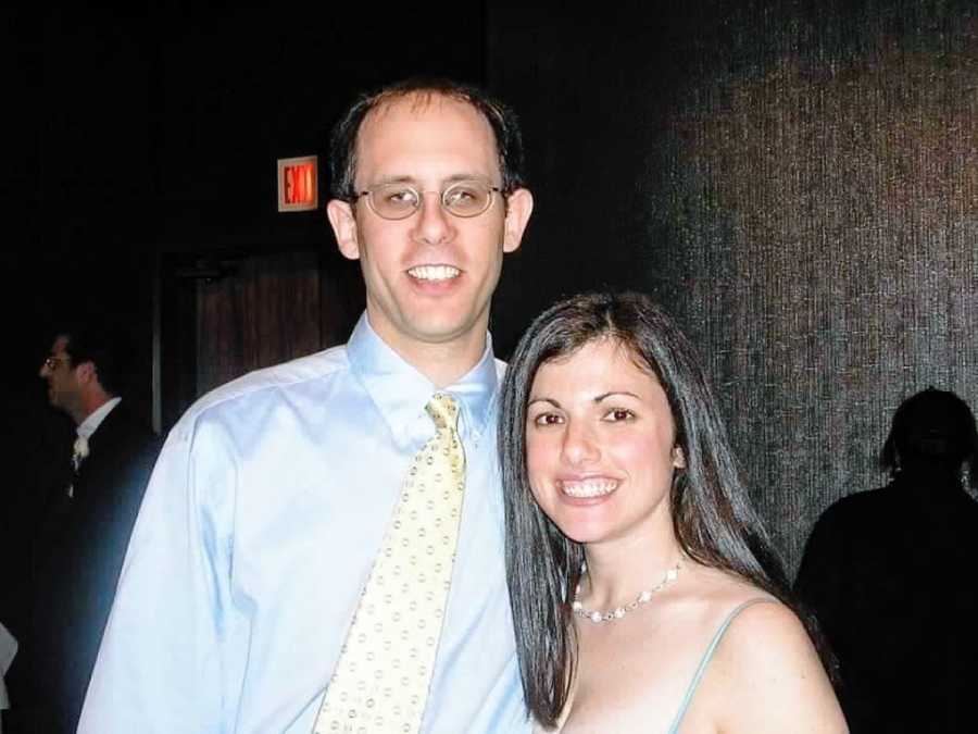 Woman smiles with her husband while they're dressed up for a formal event