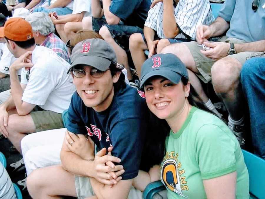 Woman poses with her then-husband at a baseball game in matching Boston Red Sox hats