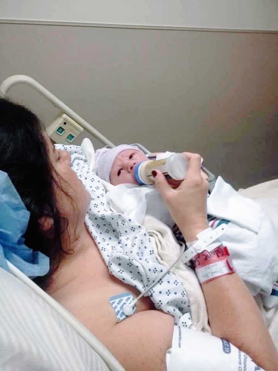 Woman bottle feeds her newborn son before placing him for adoption