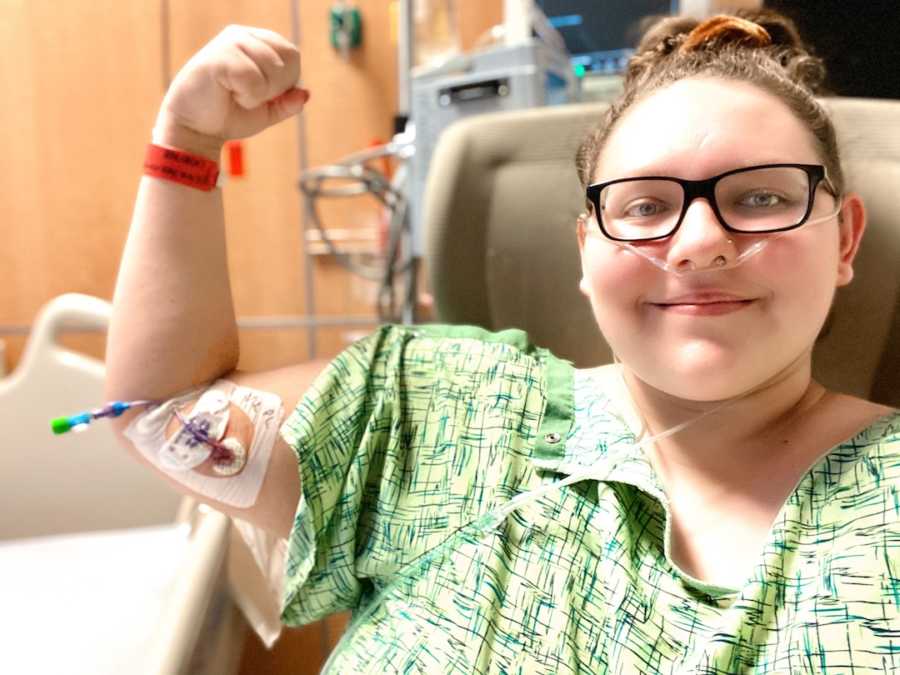 girl in hospital making muscle