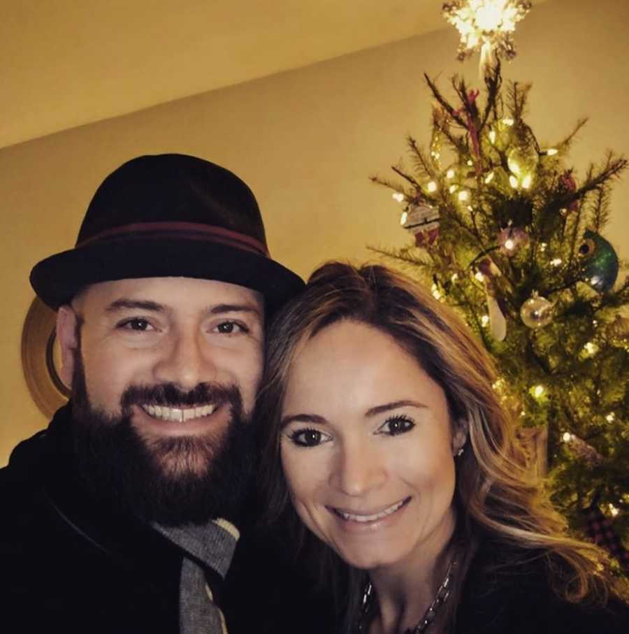 Couple smiling with Christmas tree