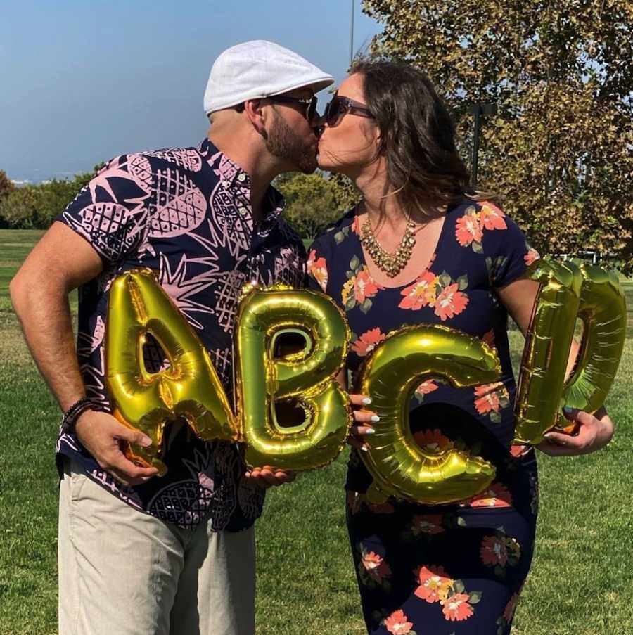 Couple kissing at quadruplet pregnancy announcement