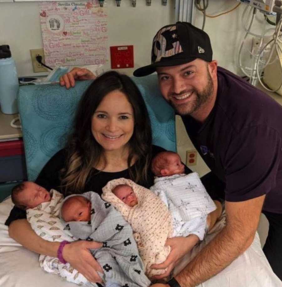 Family photo with parents holding newborn quadruplets