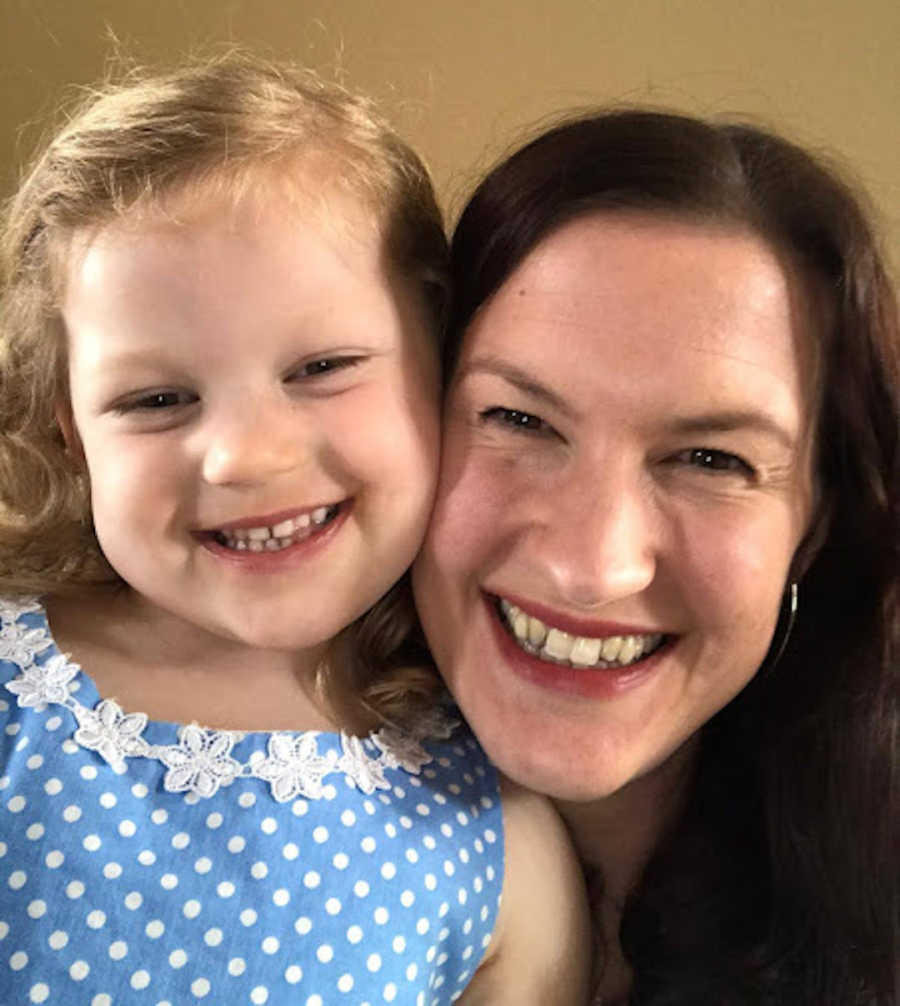 mom and young daughter smiling