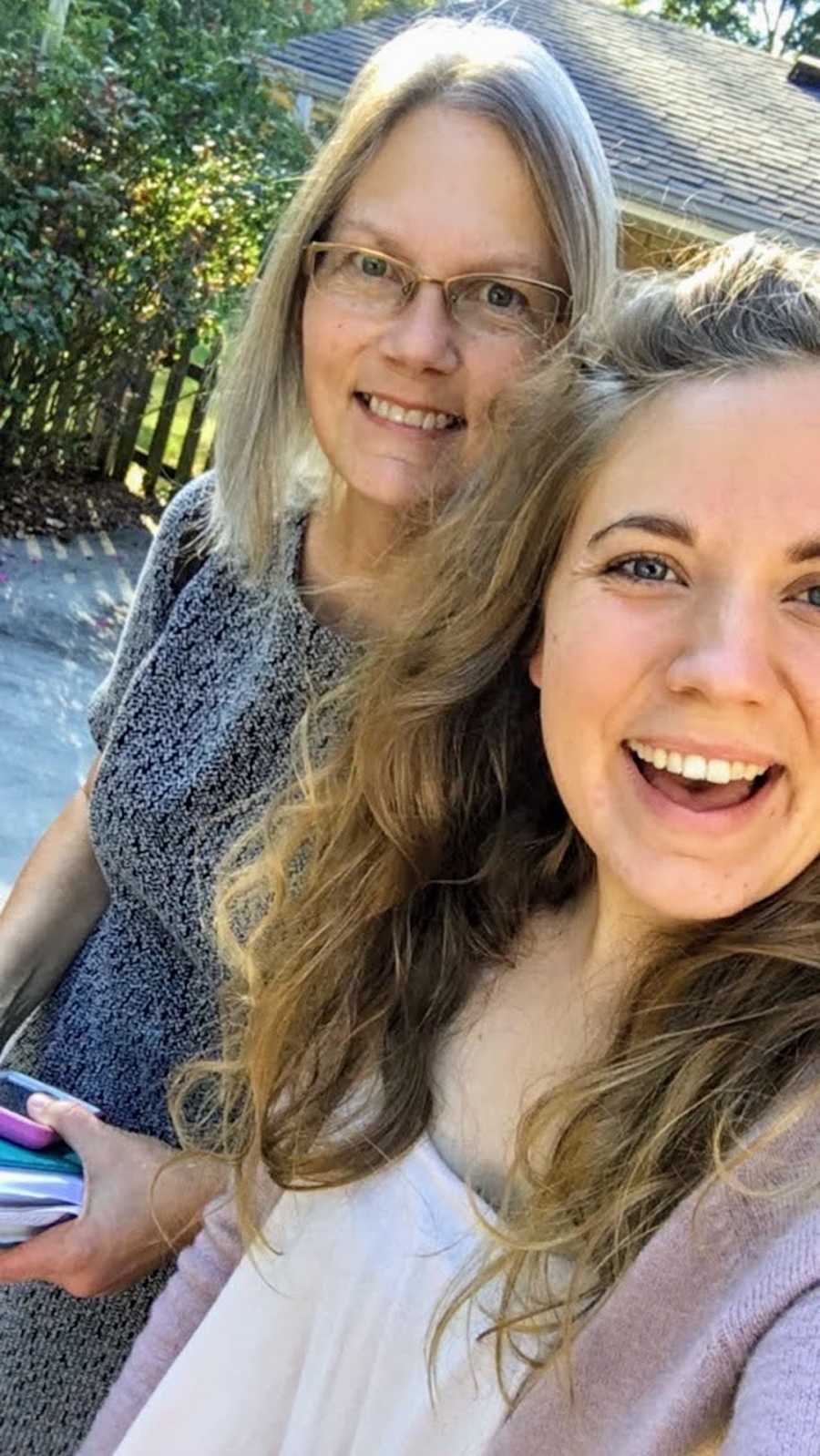 Mother and daughter outside taking smiling selfie