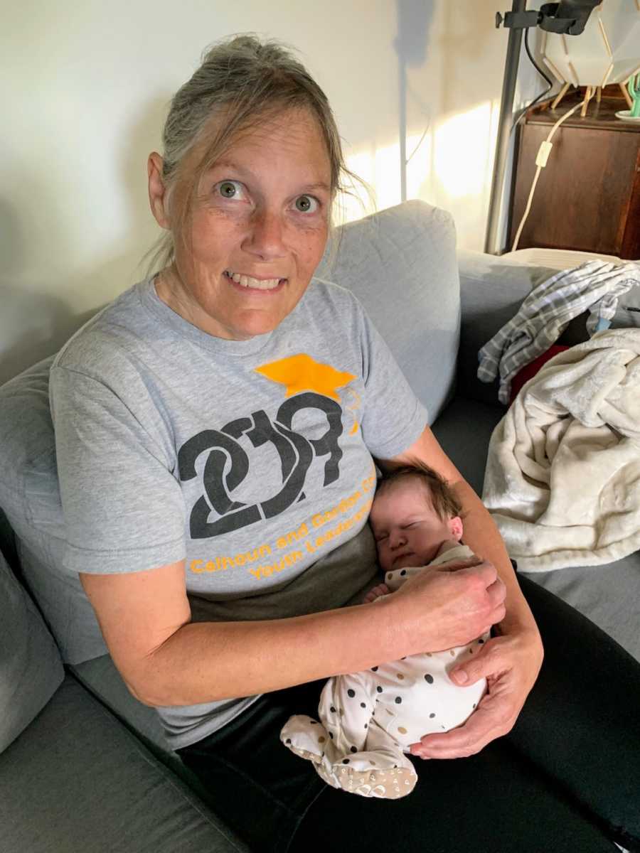 Grandmother wearing T-shirt holding newborn grandson