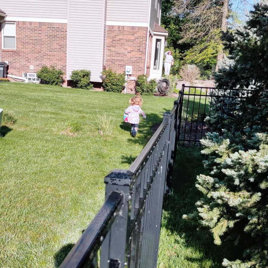 Little girl runs to greet her neighbor and babysitter on a sunny day