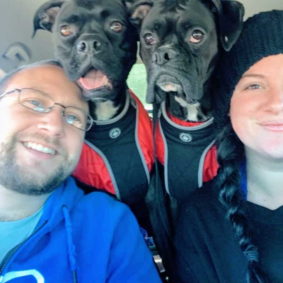 Married couple take a car selfie with two black boxers