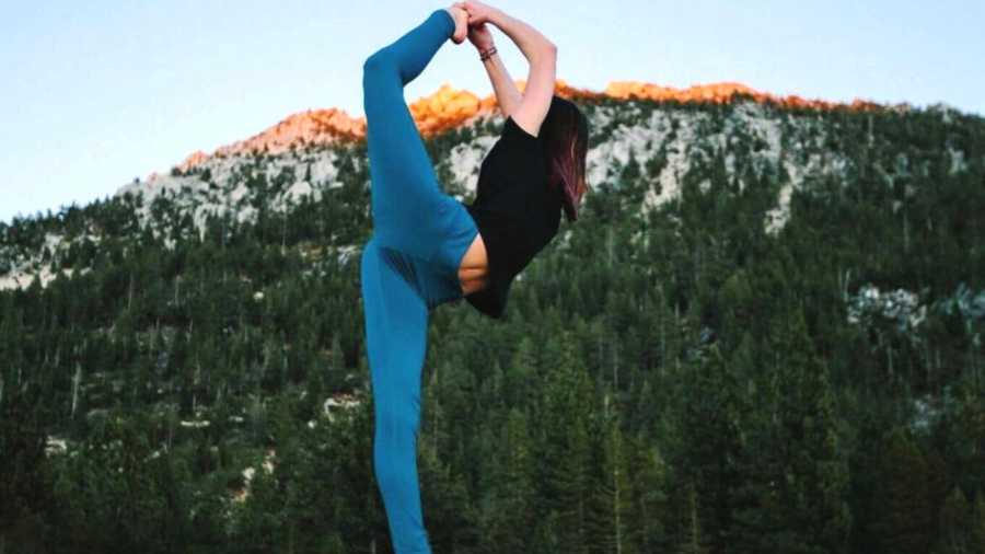 Woman in yoga pose in front of a mountain