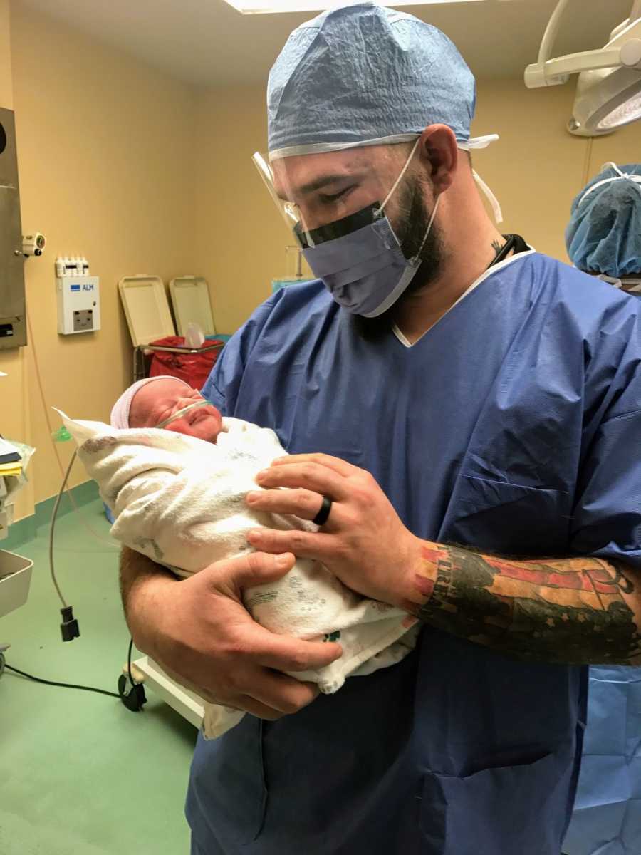 A father holds his newborn son in the hospital