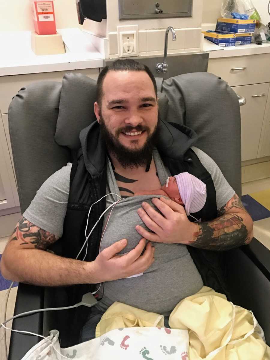 A father holds his newborn son in the hospital
