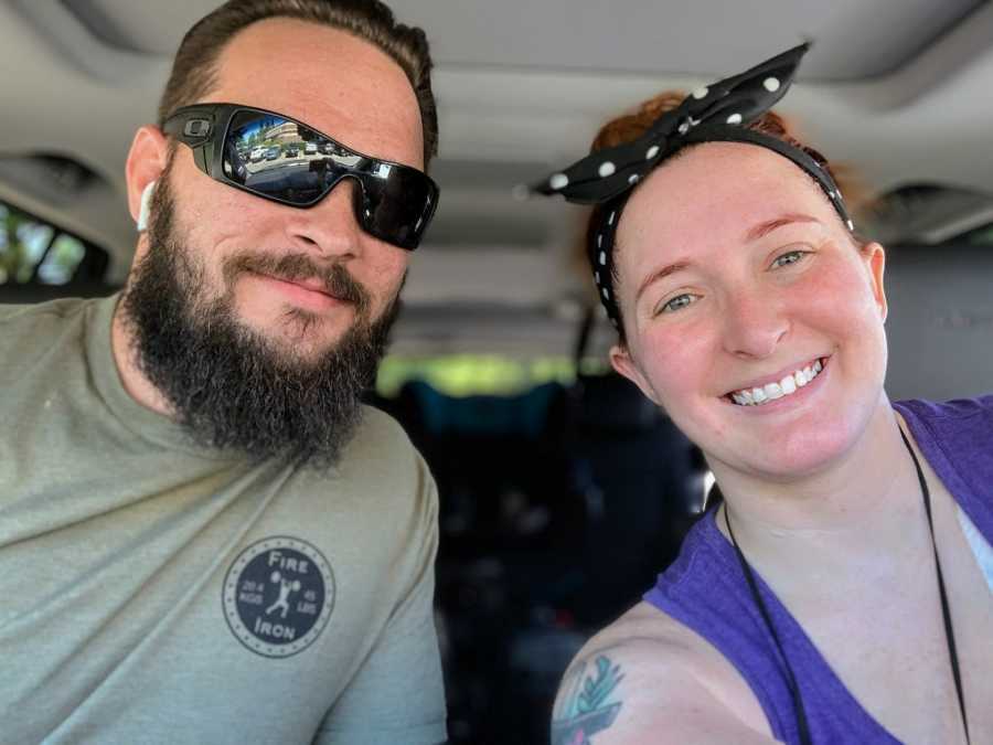 A husband and wife sit together in a car