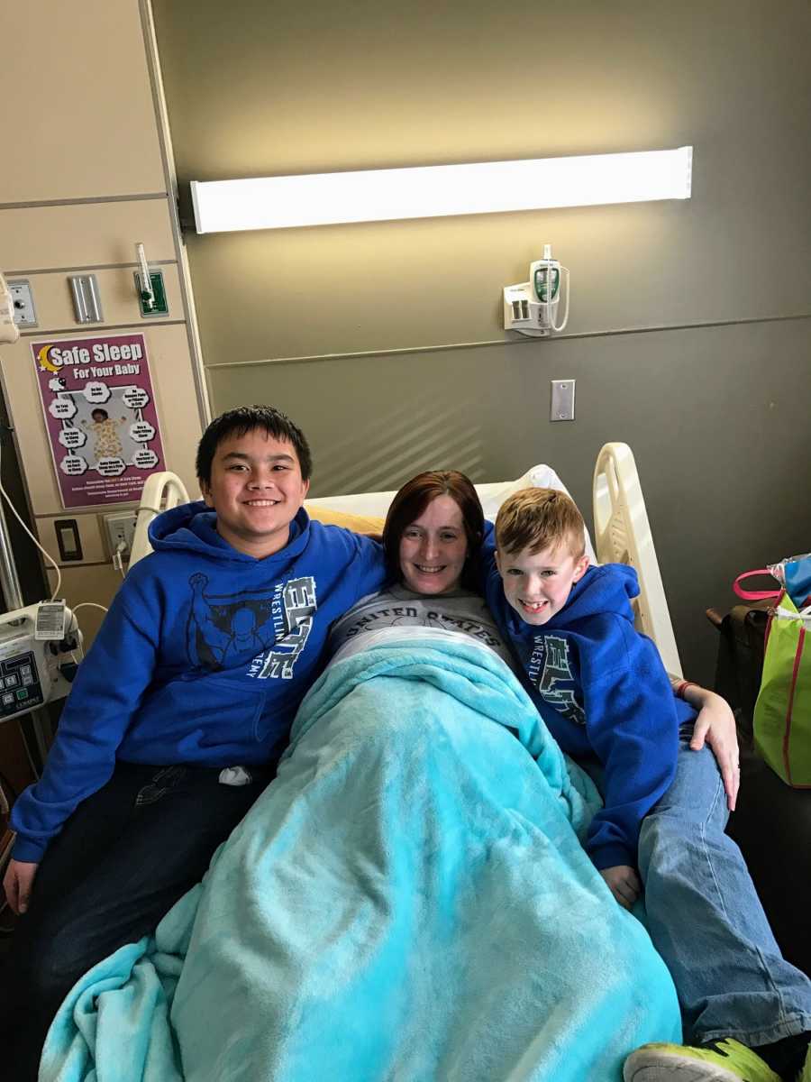 A pair of boys sit with their disabled mom at a hospital