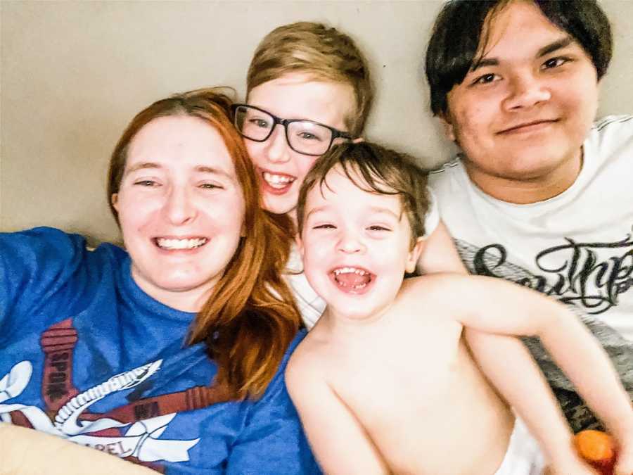 A disabled mother and her three sons smiling and laughing