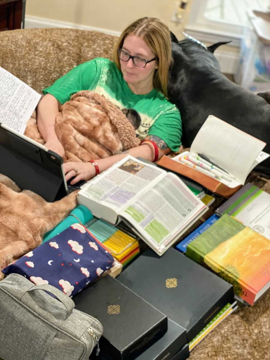 A disabled woman studies for her master's with animals nearby