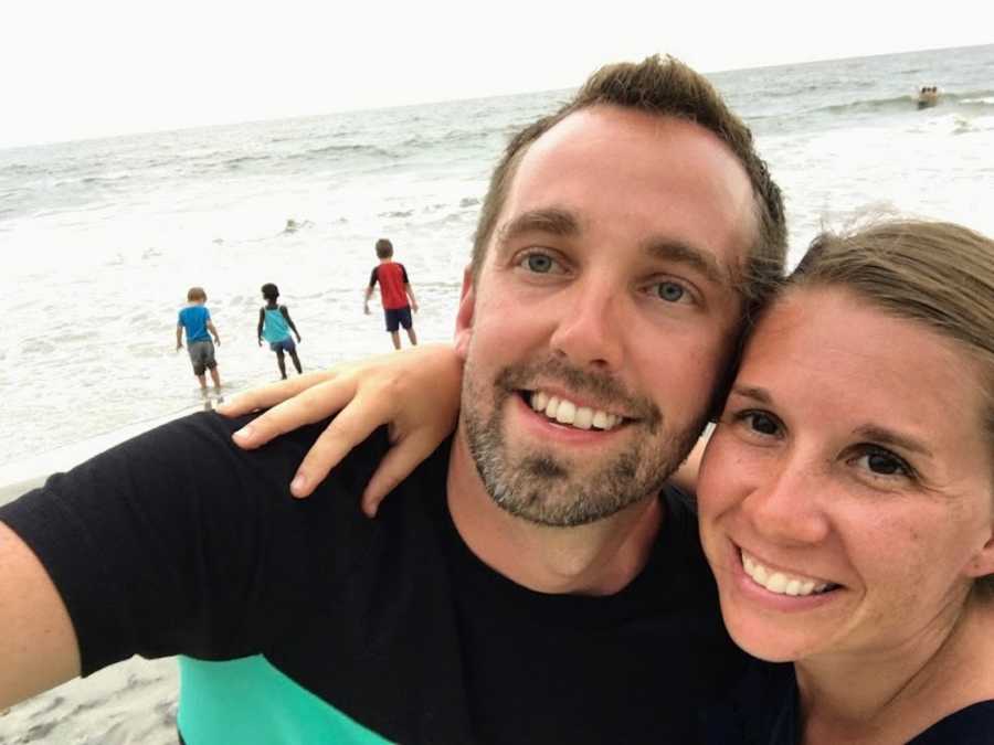 Husband and wife taking smiling selfie at beach