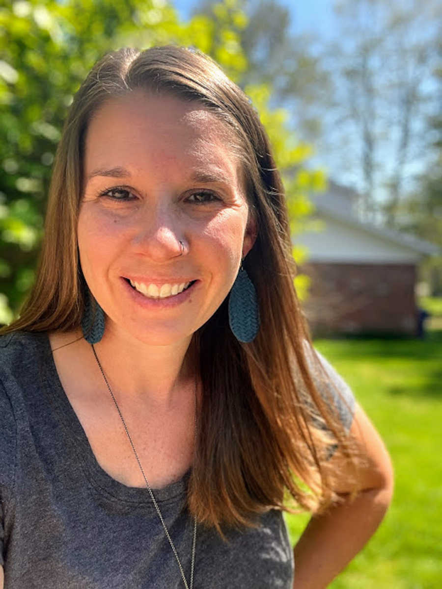 Woman taking smiling selfie outside in yard