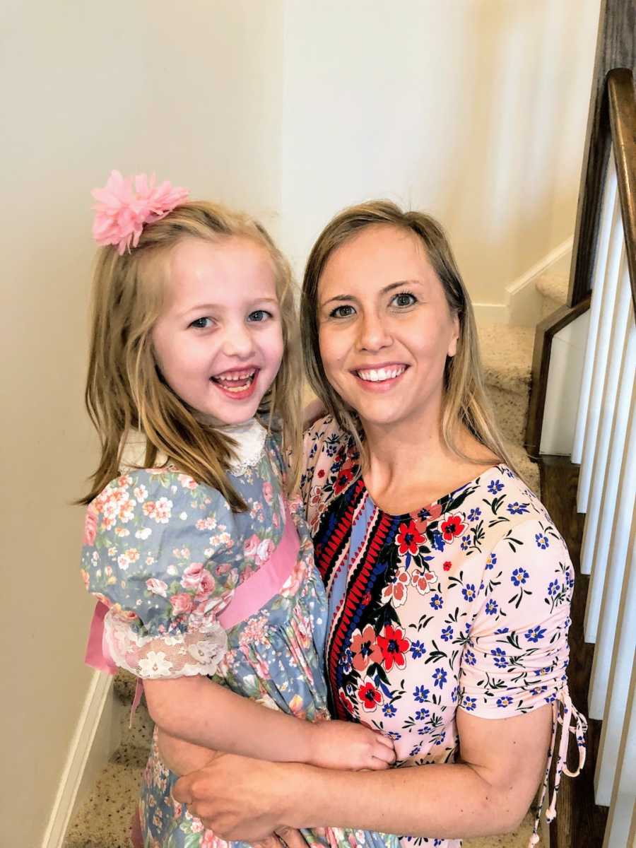 Mother holding daughter and smiling