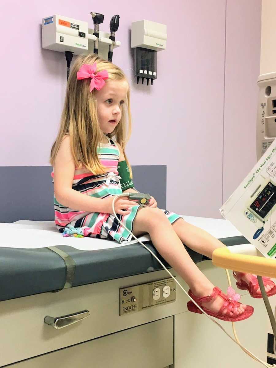 Young girl sitting on hospital bed 