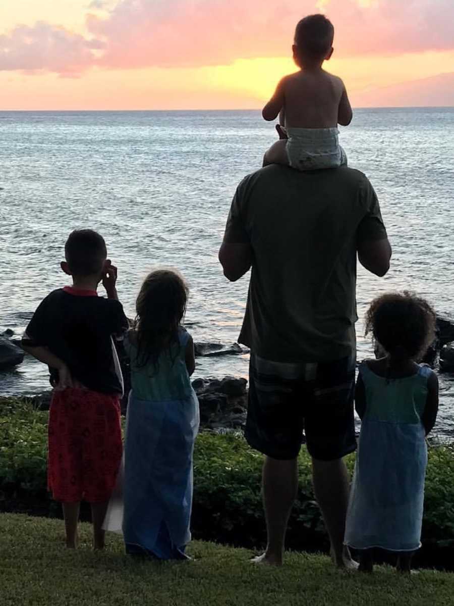 family smiling over the shore