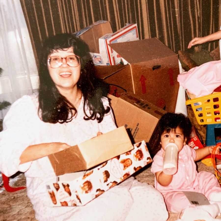 Mother and daughter sitting on the floor with boxes surrounding them 