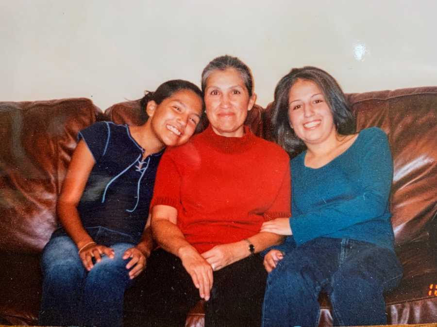 Mother sitting on leather couch with two daughters