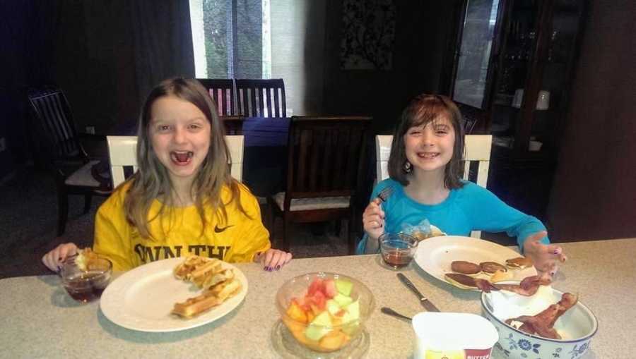 Adoptive sisters eat breakfast together at a counter