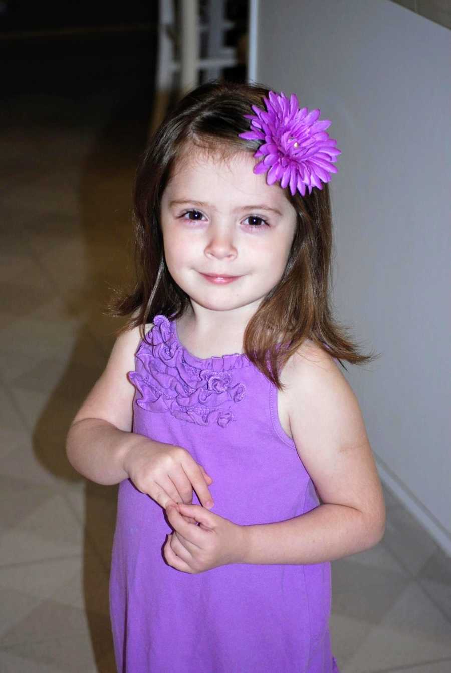 An adoptive girl wearing a purple dress