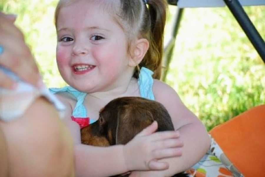 An adoptive girl hugs a dog