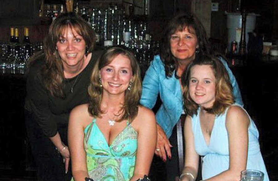 Group of four girls smiling at a bar 