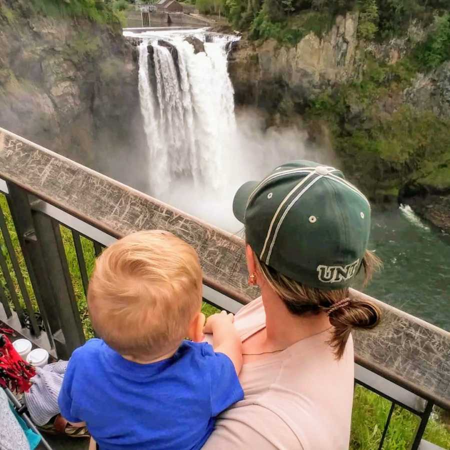 Mother and son standing at waterfall