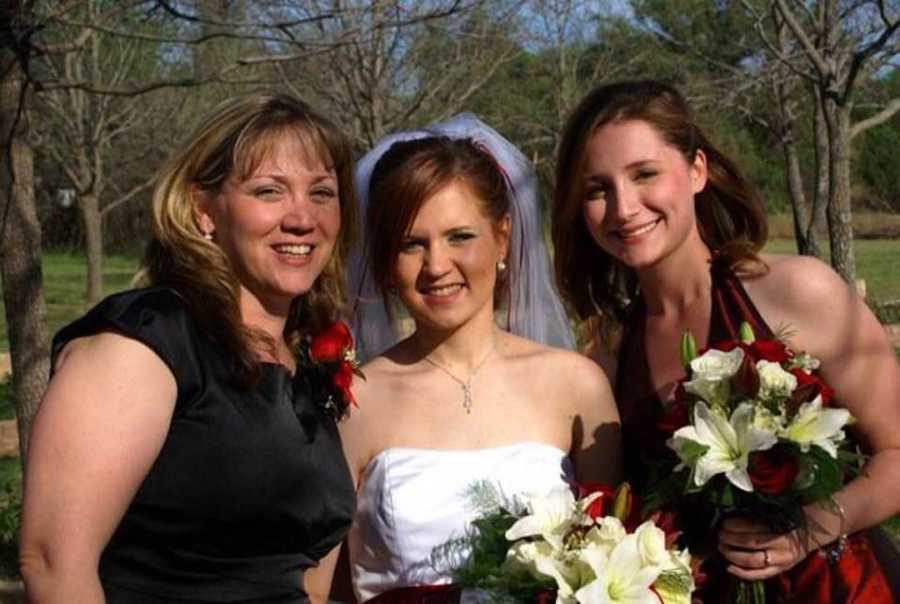 Mother and daughters at wedding smiling outside with bride