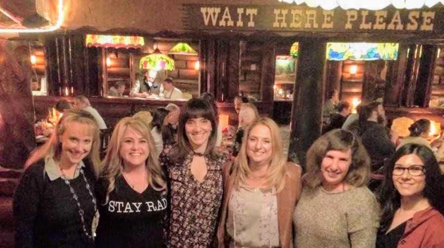 A widow stands with a group of female friends