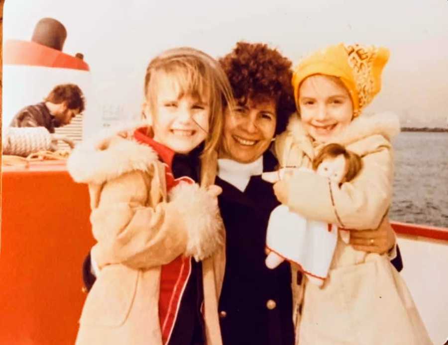 A woman stands with two children who are friends