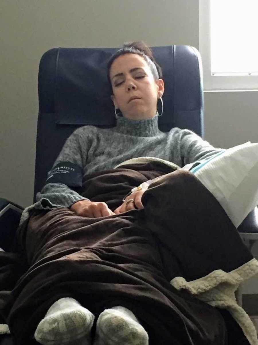 Woman wearing gray turtleneck asleep in blue leather chair