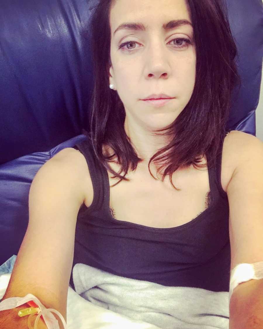 Woman with IVs wearing black tank top taking selfie