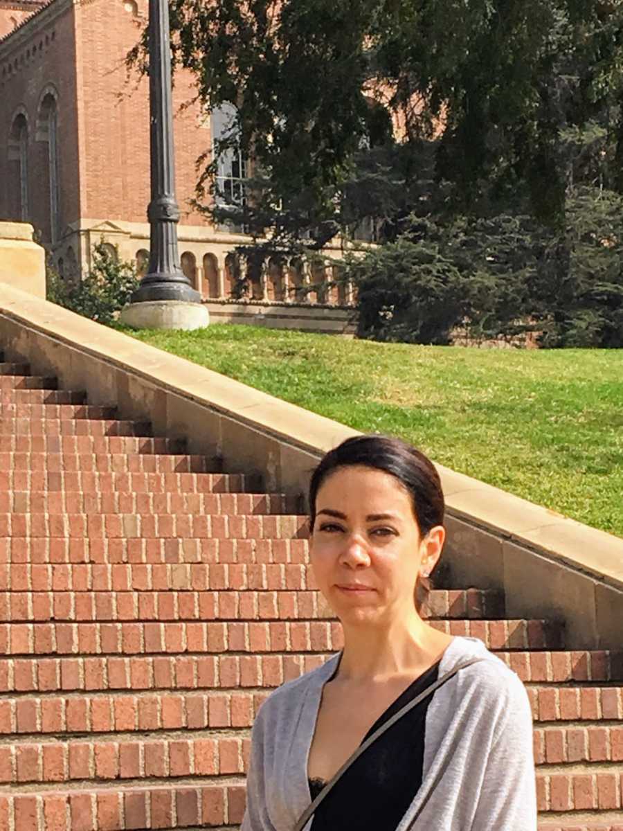 Woman smiling standing in front of red brick steps 