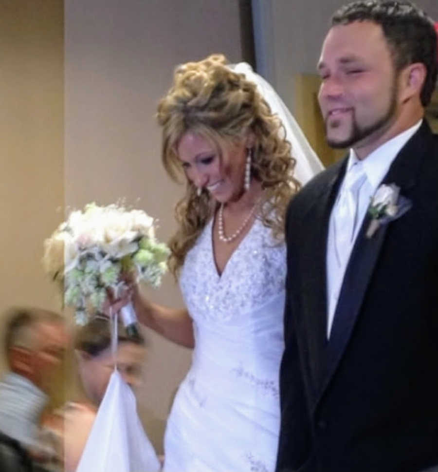 Newlywed husband and wife walking down the aisle at wedding