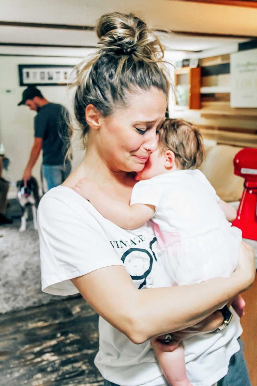 Mom holding adopted daughter and crying