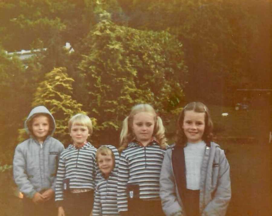 Family members standing outside wearing gray and stripes