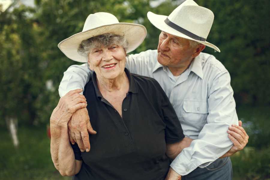 Grandparents wearing hats hugging