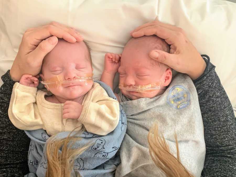 Twin boys wearing oxygen tubes lying down 