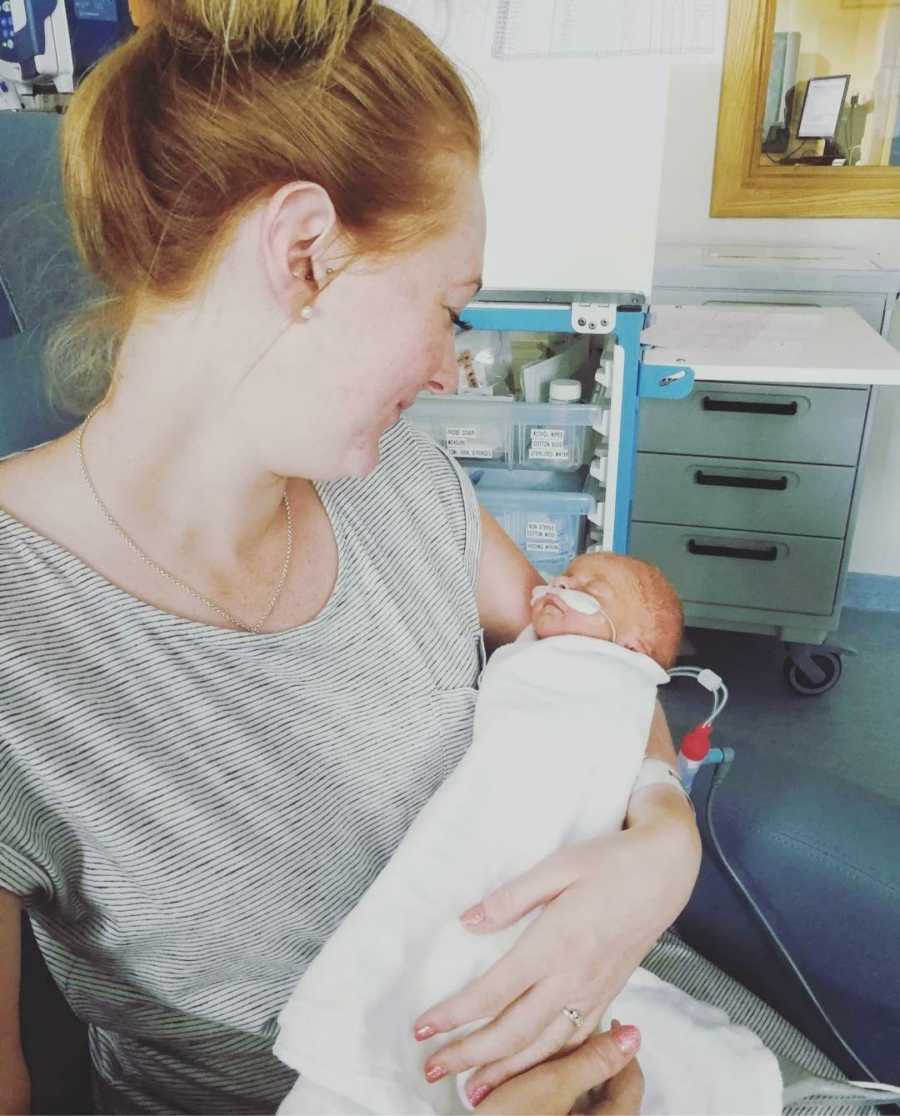 New mom holding newborn daughter in hospital