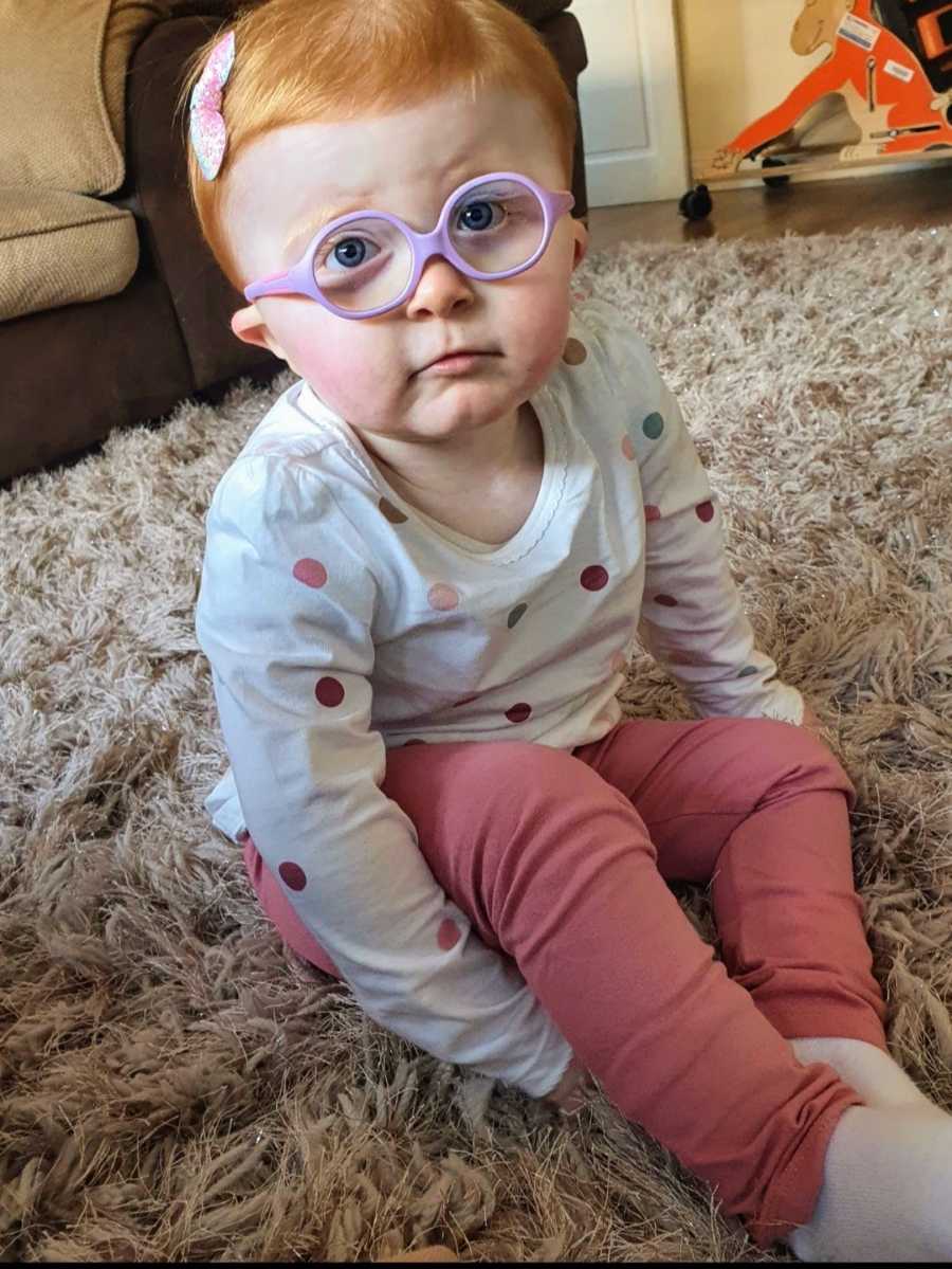 Toddler girl sitting on carpet