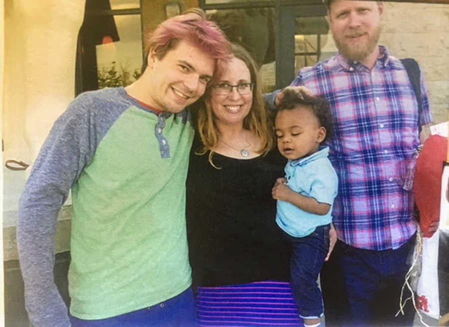 Family of four standing and smiling