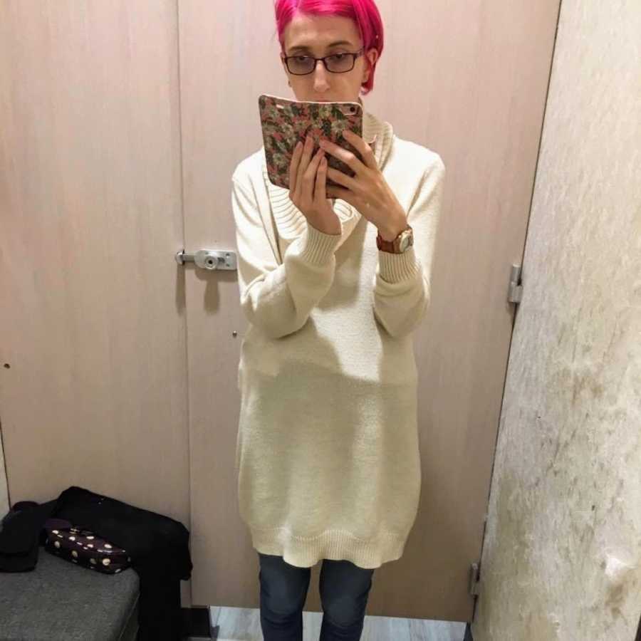 Woman with pink hair taking selfie in a dressing room