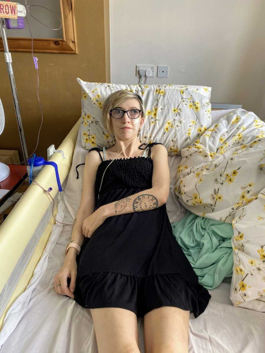 Woman wearing black dress lying in a hospital bed