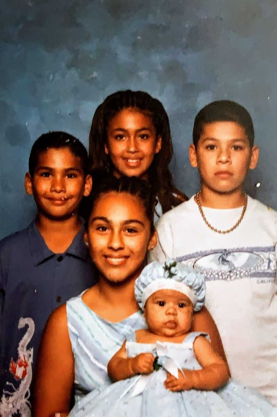 Four children and a baby taking a family photo